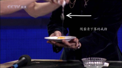 最后,劉謙將兩手手指并攏做著動(dòng)作,其實(shí),是右手食指和拇指松開,戒指瞬間被皮筋抽回到右手的袖口里面了!!由于角度的原因,觀眾是看不到戒指這一移動(dòng)過程的.劉謙張開手翻轉(zhuǎn)手掌向外,哈哈,戒指沒有了,觀眾驚嘆!!
